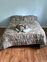 Double bed made up with floral comforter, shams and pillows on metal frame
