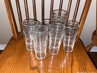 Group of clear glass tumblers on wooden chair
