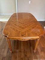 Top view showing chevron grain pattern and turned legs of oak dining table