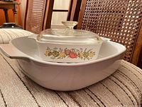 Square casserole with lid nested inside white roaster