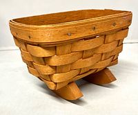 Side view showing woven body, nailed rim, rocker feet