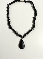 Necklace laid flat showing chip beads and teardrop pendant