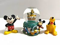 Front view of snow globe with attached Mickey plus separate Mickey and Pluto figures