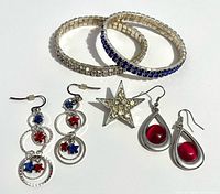 Group shot of all jewelry items: two bracelets, star brooch, two pairs of earrings