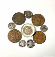 Front view of 11 coins arranged in circle showing patina and wear