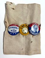 Front view of three pinback buttons on fabric