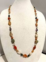 Full view of gemstone bead necklace on display bust
