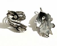 Front view of adjustable ring and brooch pendant showing floral design and rhinestones