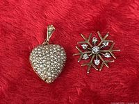 Front view of both pendants on red fabric