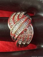 Front view of ring showing baguette and round diamonds, missing stones visible
