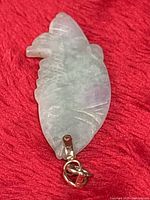 front view of carved jade fish pendant with gold bail