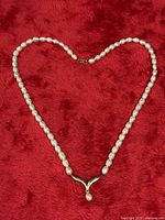 Strand arranged showing pearls, center fitting, clasp