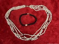 Necklace and bracelet laid flat on red background
