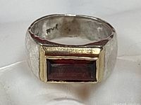 Close-up of ring front showing garnet and gold bezel