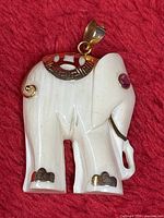 Frontal view of elephant pendant showing gold accents and ruby eye