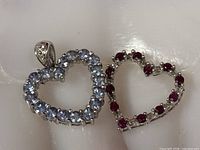 Both heart pendants side by side showing stone colours and overall size