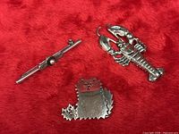 Three sterling silver brooches: lobster, bar with bead, cat-shape