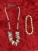 Necklace and bracelet laid flat on red fabric
