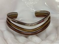 Front view of tri-color cuff bracelet showing sterling, brass and copper bands