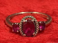 Front view of ring showing three ruby stones and silver setting