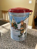 Front view of Tim Hortons Skating Pond tin showing winter scene and red lid