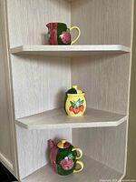 All three strawberry-themed ceramic pieces on shelf