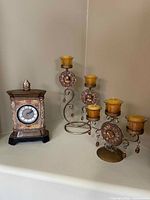 Mantel clock and candle stands grouped together