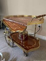 overall view showing bar cart top leaf folded down, brass rails, wheels, lower tier with ice bucket