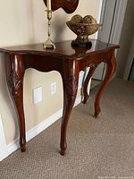 Front view of carved wood console table against wall