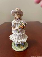 Front view of porcelain girl figurine holding flowers