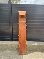 Full front view of wooden toboggan showing deck, side hardware, rope