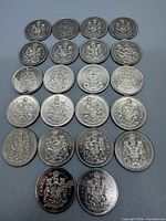 Front view of all 18 Canadian 50-cent coins showing Coat of Arms reverse designs