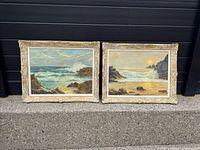 Both framed coastal oil paintings side by side