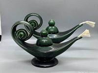 Front angled view of both green ceramic genie lamps showing spiral handles, tops, and wicks