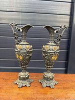 Full view of both cast metal ewers on table