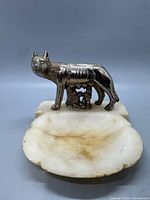 Front view of metal wolf figure on stone dish
