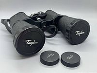 Binoculars front view with objective caps on and two loose caps shown
