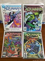 All four Aquaman issues laid out in bags and boards