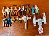 Group shot of all figures and vehicles displayed on wood surface