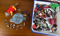 overall view of loose cat figure, round platform, silver weapons, small silver figures and tray full of assorted parts