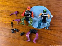 Full view of all figure parts, weapons, connectors on wooden surface