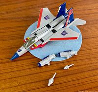 Jet figure with three accessories displayed on surface
