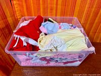 Top view of bin filled with assorted vintage Cabbage Patch Kids doll clothes