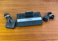 Console with cartridge inserted, joystick and power adapter