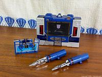 Soundwave figure in cassette-recorder mode beside cassette robot and two missile accessories