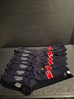 Eight pairs folded dark socks with tags visible
