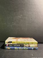 Spine view of three DVD cases showing titles Away From Her, Call the Midwife, Nine Good Teeth