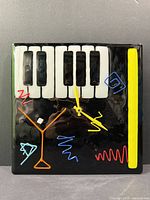 Front view of fused glass wall clock showing piano keys and colourful design