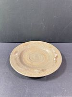 Top view showing textured grey ceramic plate with swirl center and rim design