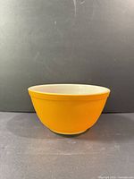 Full side view of orange Pyrex bowl